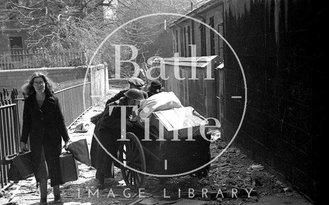 An elderly couple are helped moving their possessions along Bridewell Lane, Bath 1942