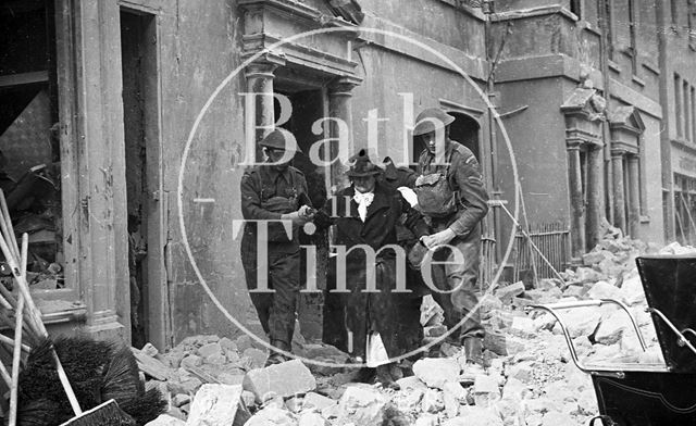 An elderly lady is helped from her home in Burlington Place, Julian Road, Bath 1942