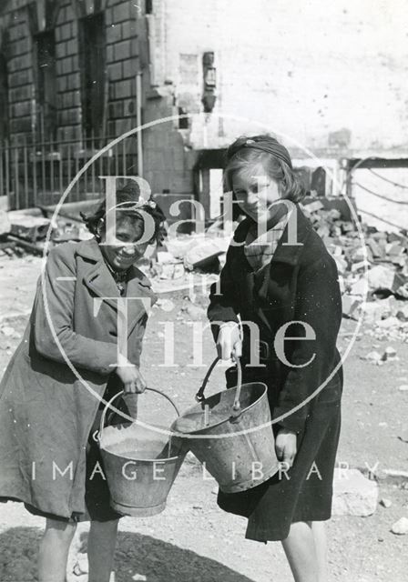 Two young girls happily go to fill their buckets outside, 19, Green Park, Bath 1942