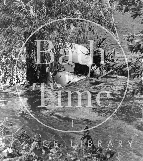 A swept away van against a tree in Keynsham, Somerset 1968