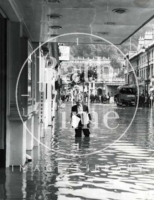 A newspaper seller at the Odeon, Southgate Street, Bath during the floods 1968