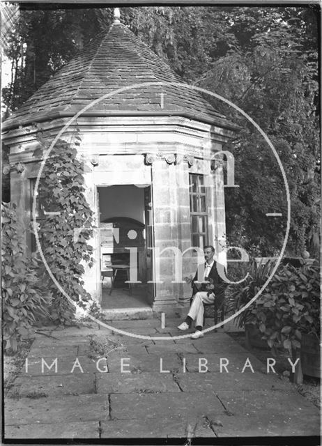 A gentleman sitting outside garden gazebo, Iford Manor c.1920s