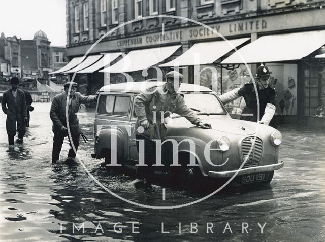 Pushing a waterlogged car in a flooded High Street, Chippenham, Wiltshire 1960