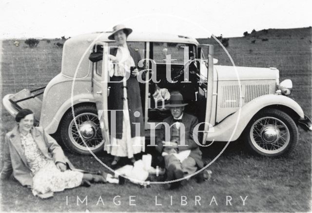 The photographer, his wife Violet and female friend picnic with the car, possibly on Bathampton Down c.1920