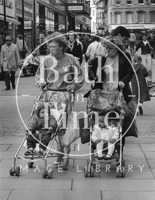 Two young mothers pushing their children down Union Street, Bath c.1980