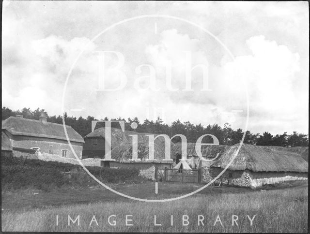 An unidentified farmhouse and thatched farm buildings c.1900