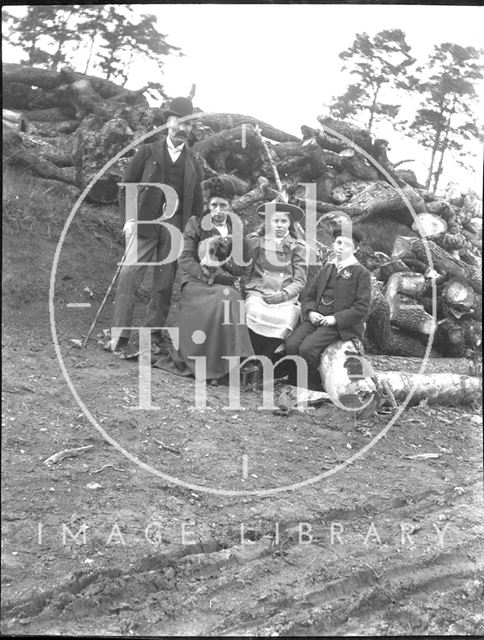 An unidentified family portrait in front of a pile of logs c.1900