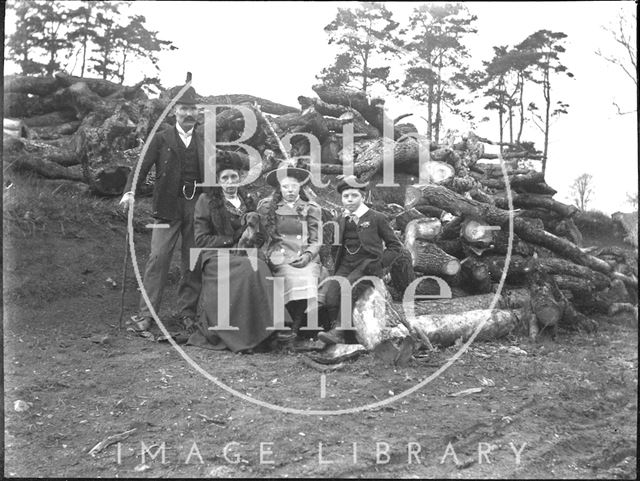 An unidentified family portrait in front of a pile of logs c.1900