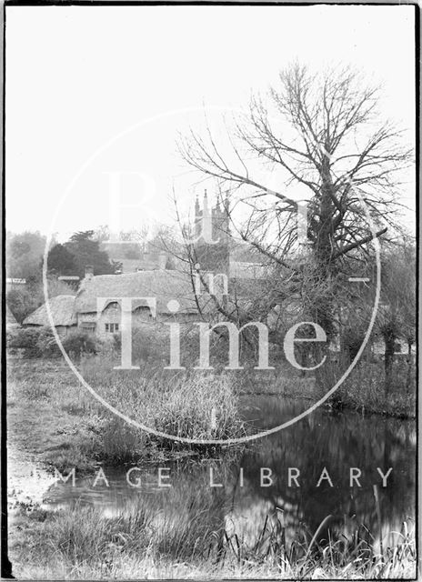 Village scene with thatched cottage and church, Fisherton de la Mere, Wiltshire c.1930