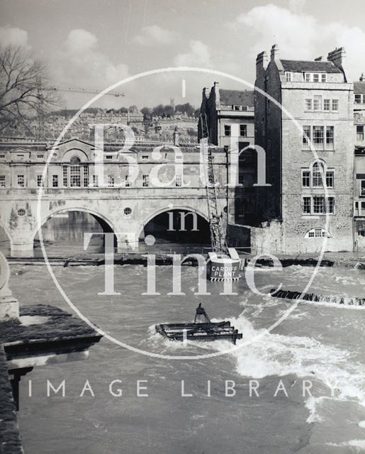 A flood, partially submerging a crane, during the construction of the new weir at Pulteney Bridge, Bath c.1973