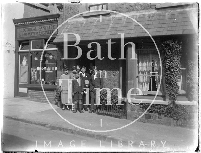 Group posing outside an electrical, sanitary and water engineering shop, Minehead, Somerset 1926