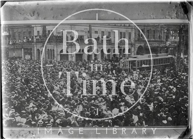 Crowded city scene with tram possibly Wellington, H.M.S. New Zealand c.1915