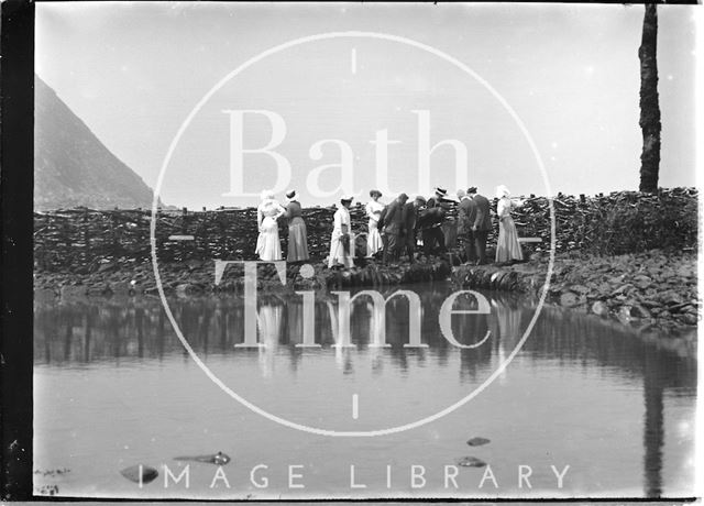 A fine group of people watching a man with a fishing net at Lynmouth, Exmoor, Devon c.1910