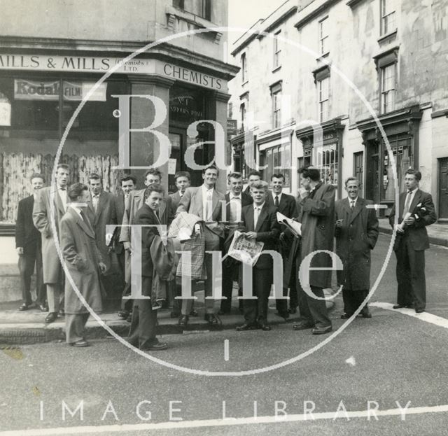 A group of men standing outside Mills & Mills chemists in Larkhall, Bath 1950s