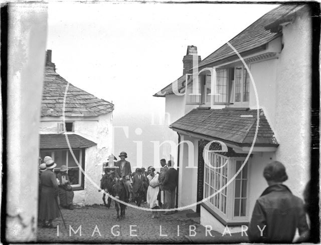 Riding a donkey up the cobbles, Clovelly, Devon c.1930