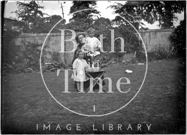 Children and their nanny in a garden c.1915