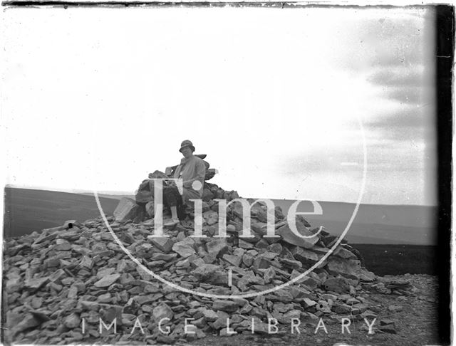 The photographer's wife Violet sitting on top of a pile of rocks, Dunkery Beacon, Somerset c.1920