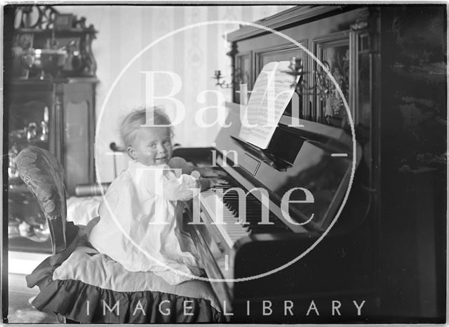 One of the photographer's twins playing the piano 1912