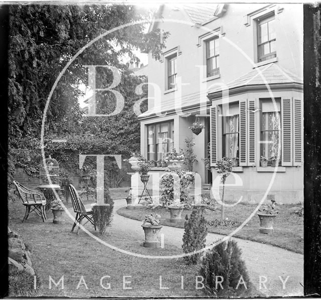 A tranquil garden with chairs outside an unidentified house c.1900