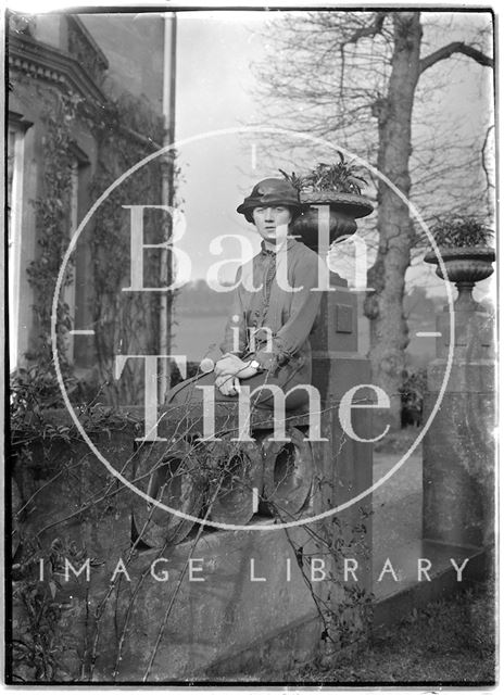 A young woman posing at the front of Monkton House, Limpley Stoke, Wiltshire c.1900