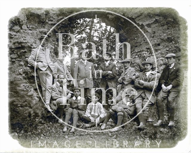 The photographer in self-portrait and a group of others under a stone arch c.1890