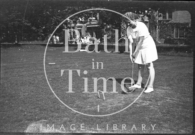 A young girl playing croquet at an unidentified location c.1950