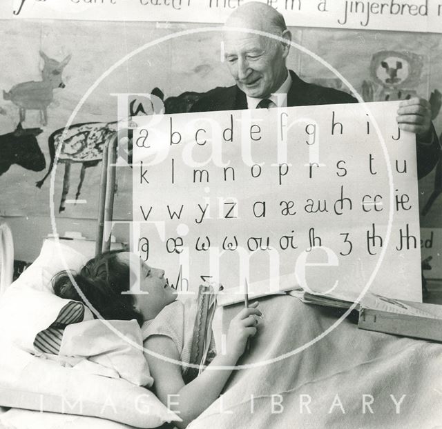 Sir James Pitman teaching a bedridden girl the alphabet c.1960