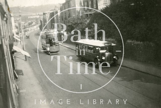 A tram and bus appear to race up the Wells Road, Bath 1936