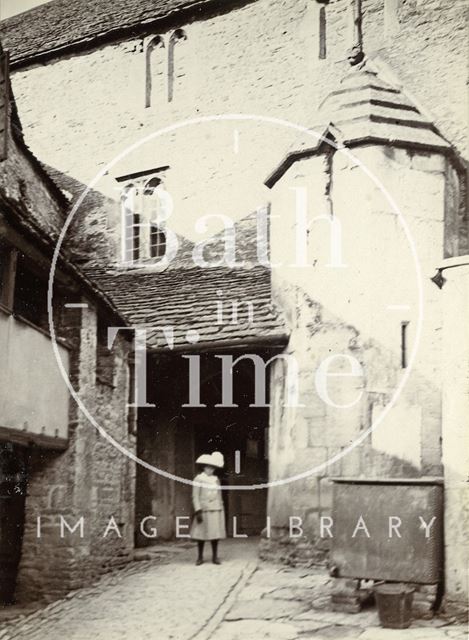 A girl posing in the courtyard of the George Inn, Norton St. Philip, Somerset c.1901