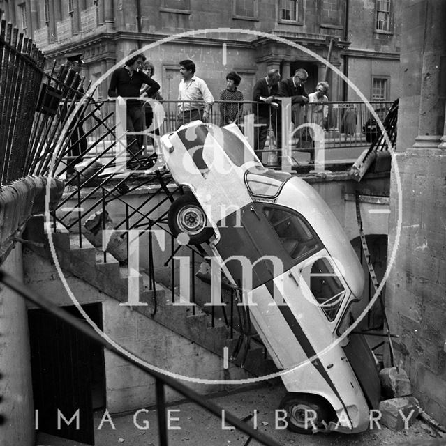 A car that has crashed through the railings at the Circus, Bath c.1960