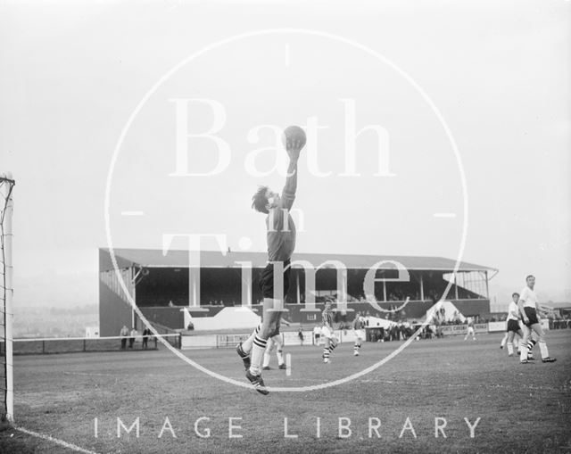 The goalkeeper of the visiting team catches the ball at Twerton Park, Bath c.1963