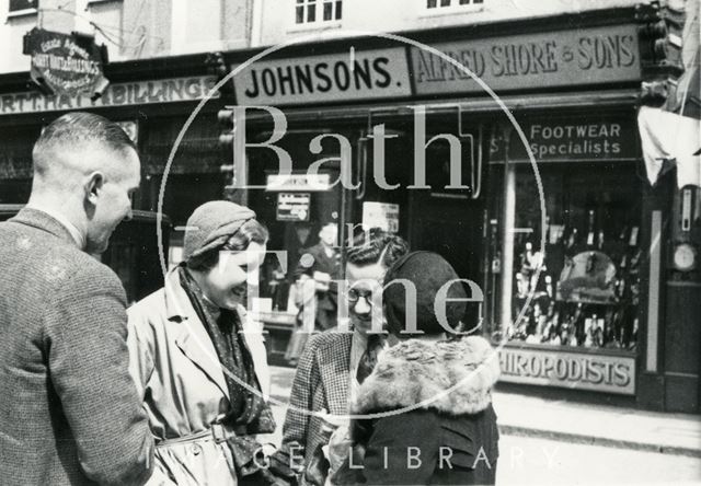 A group of shoppers chat outside Alfred Shore & Sons, Burton Street, Bath c.1935