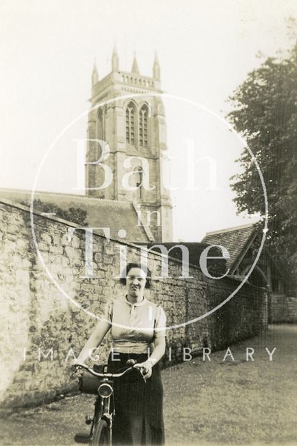 A lady with her bicycle outside St. Swithun's Church, Bathford c.1920