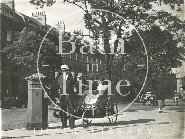 A man gets out of his Bath chair to post a letter in the tree-line Great Pulteney Street, Bath c.1930