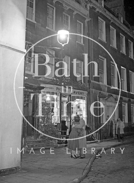 A couple embrace outside Philippa Savery, antiques, 2, Abbey Street, Bath c.1950